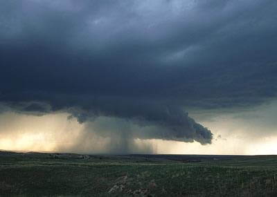 This photograph of a <a
  href="/earth/Atmosphere/clouds/cumulonimbus.html&edu=high&dev=">cumulonimbus cloud</a> was taken on the <a
  href="/earth/grassland_eco.html&edu=high&dev=">grasslands</a> of eastern Wyoming.
  Notice the <a
  href="/earth/Atmosphere/precipitation/rain.html&edu=high&dev=">rain</a> and <a
  href="/earth/Atmosphere/precipitation/hail.html&edu=high&dev=">hail</a> falling from this
  cloud! Cumulonimbus clouds form during <a
  href="/earth/Atmosphere/tstorm.html&edu=high&dev=">thunderstorms</a>, when very warm, moist air rises into cold air. As this humid air rises, water vapor <a
  href="/earth/Water/condensation.html&edu=high&dev=">condenses</a>,
  and forms huge <a
  href="/earth/Atmosphere/clouds/cumulonimbus.html&edu=high&dev=">cumulonimbus</a>
  clouds.<p><small><em>         Photo courtesy of <a href="http://www.inclouds.com">Gregory Thompson</a></em></small></p>